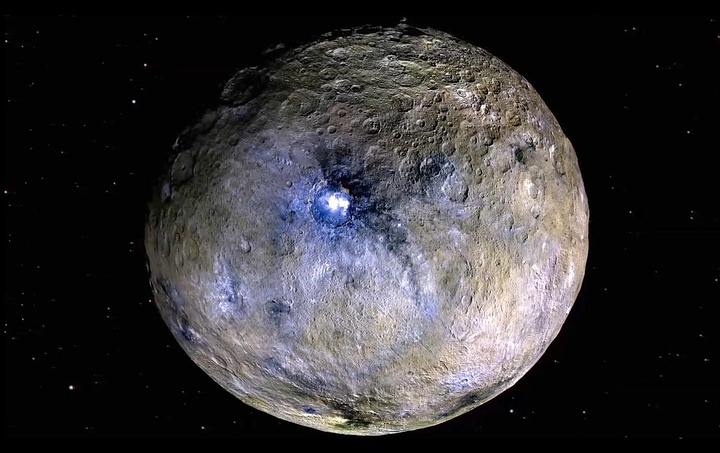 O planeta anão Ceres é mostrado nesta imagem com cores realçadas, feita a partir de fotos da missão Dawn da NASA. Novos modelos térmicos e químicos, baseados nos dados da missão, indicam que Ceres pode ter tido, há muito tempo, condições adequadas para a vida. Crédito: NASA/JPL-Caltech/UCLA/MPS/DLR/IDA.